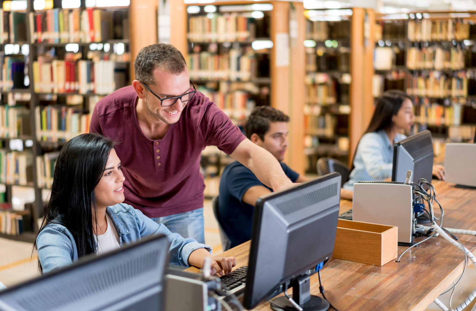 Librarian helping students using computers at the library